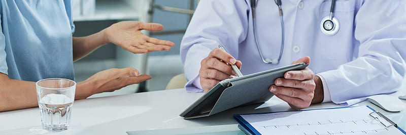 doctor-pointing-digital-tablet-screen-while-explaining-something-patient-1