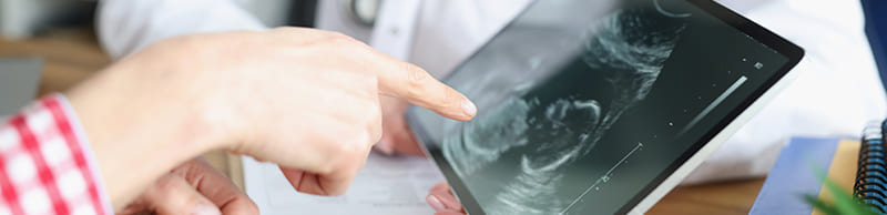 woman-doctor-showing-digital-tablet-with-ultrasound-picture-fetus-clinic-closeup